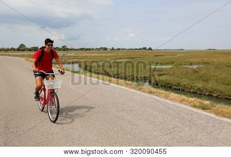 Young Boy With Red Bike In The Plain In Summer