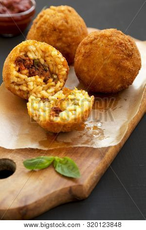 Homemade Fried Arancini With Basil And Marinara Sauce On A Black Background, Side View. Italian Rice