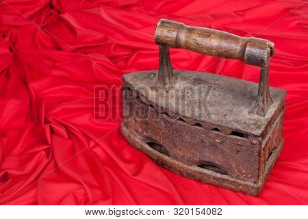 Old Rusty Iron And A Piece Or Red Textile On Isolated Background