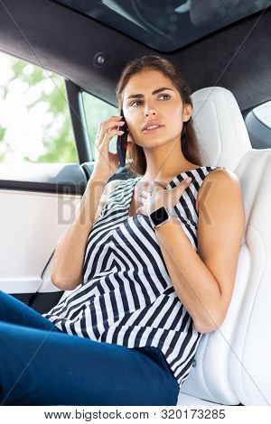 Businesswoman Calling Her Secretary While Sitting In The Car