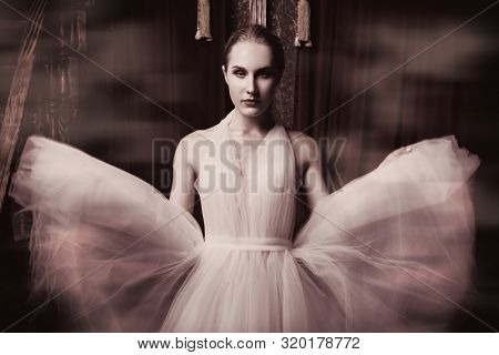 A portrait of an elegant refined female ballet dancer posing in the vintage interior. Talent, fashion for ballet dancers. 