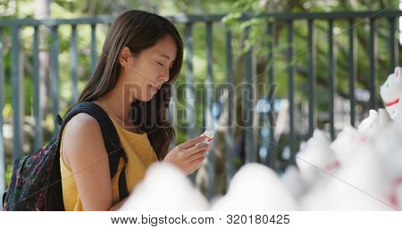 Woman put a little cat into Gotokuji temple 