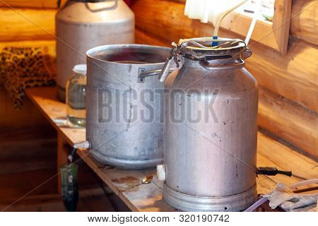 The Process Of Preparing Moonshine In A Village Bath In A Primitive Moonshine Distilling-apparatus. 