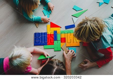 Teacher And Kids Play With Puzzle, Doing Tangram