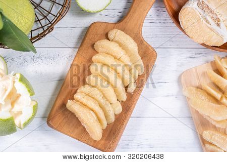 Fresh Peeled Pomelo, Grapefruit, Shaddock With Green Leaf On Bright Wooden Plank Table. Seasonal Fru