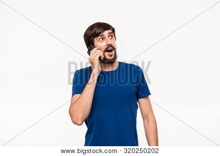 Handsome Brunet Man In A Blue Shirt With Beard And Mostaches Smiling Speaking On The Smartphone Stan