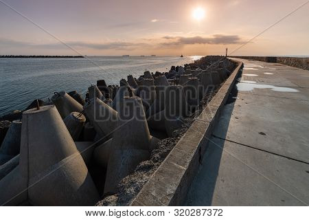 North Pier With Breakwaters, Sunset Seascape. Tetrapods Along Edges Of Pier. Beautiful Evening Seasc