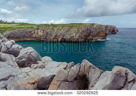 Line Of Rocks Leading A View Of A Cliff In A Cloudy Day, Location Bufones De Pria, Asturias, Spain