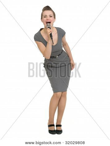 Full Length Portrait Of Happy Woman Singing In Microphone Isolated