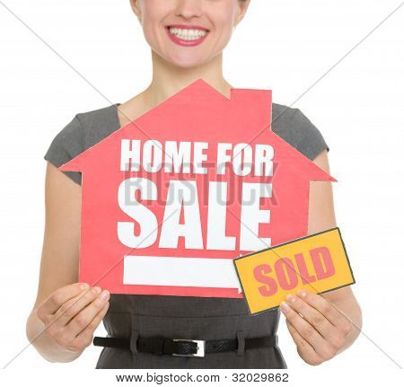 Closeup On Home For Sale Sold Sign Holding By Happy Female Isolated