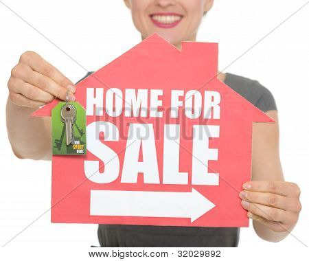 Closeup On Home For Sale Sign And Keys Holding By Happy Female Isolated