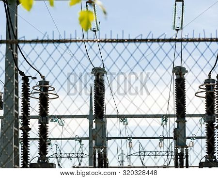 View Through Security Fence Of High Voltage French Power Lines Hydroelectric Power Plant At Centrale
