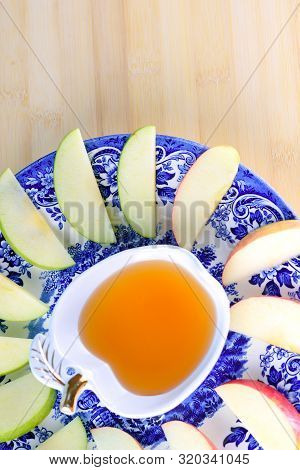 Jewish Holiday Rosh Hashana Background With Honey And Slices Of Apple On Wooden Table. During The Je