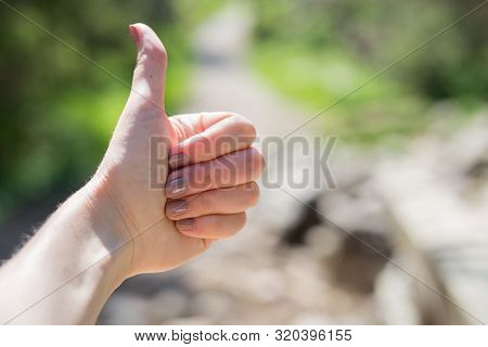Fimale Traveler Showing Thumb Up Against The Backdrop Of Nature. Tourism Concept. Copyspace