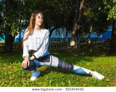Girl In Green Sports Top And Leggings Trains On Street, Girl Doing Stretching , Sportswoman, Workout
