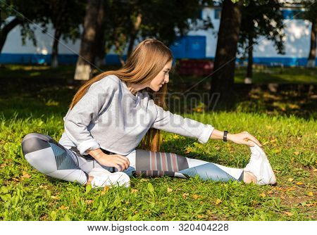 Girl In Green Sports Top And Leggings Trains On Street, Girl Doing Stretching , Sportswoman, Workout