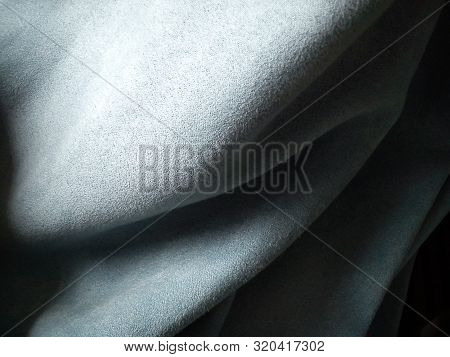 Close-up Of Velvety Fabric For Curtains Of Gray-blue Color Pleated With The Play Of Chiaroscuro