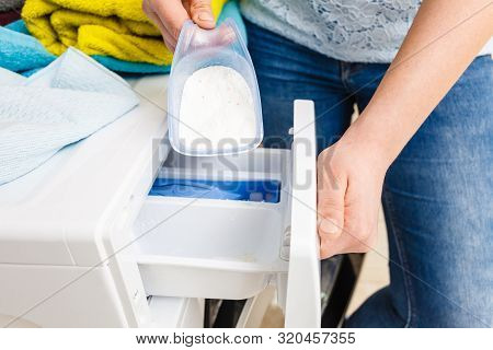 Washing Powder Detergent And Measuring Cup Pouring Into Machine. Household Duties, Clothes Laundry O