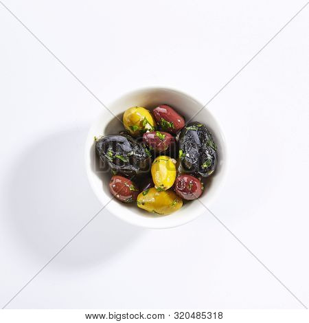Delicious olive assorti marinated in oil top view. Mediterranean cuisine restaurant dish, menu item. Tasty greek snack, appetizer isolated on white background. Organic food, natural vegetarian meal