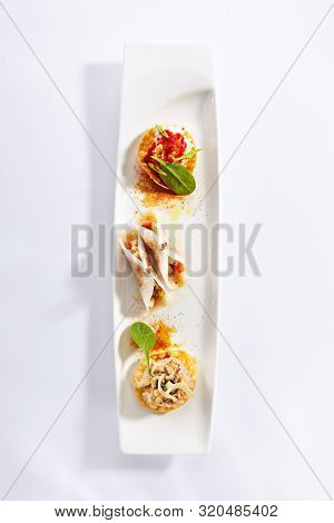Taco with seafood assorti top view. Mexican traditional dish. Wheat tortilla with sea food fillings on plate. Served delicious snacks. Appetizer composition isolated on white background