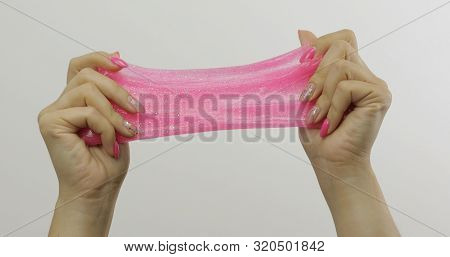 Woman Hands Playing With Oddly Satisfying Pink Slime On White Background. Sticky Gooey Substance. Re