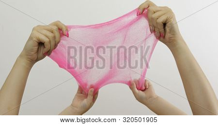 Woman And Child Hands Playing With Oddly Satisfying Pink Slime On White Background. Sticky Gooey Sub