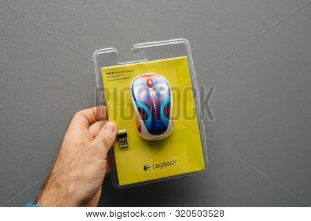 Paris, France - Oct 21, 2017: Man Hand Holding Logitech M317c Wireless Mouse Isolated On Gray Backgr