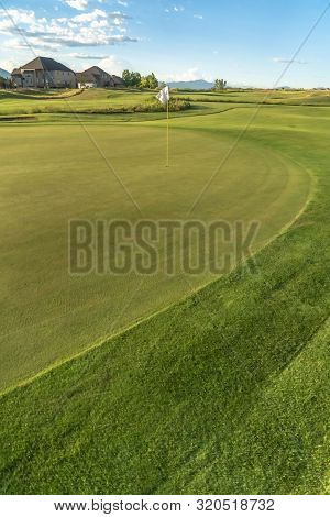 Vivid Green Fairway Of A Golf Course With A Hole And Flagstick At The Center