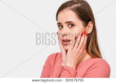 Close-up Studio Shot Of Amazed Beautiful Young Woman Looking At One Side With Surprised Expression A