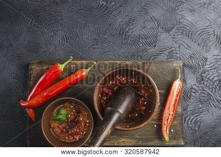 Spicy Chili On A Dark Background In Ceramic Plates On A Wooden Board, Flatlay. Used As An Ingredient