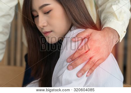 Businessman Putting Hand On The Shoulder Of Female Employee In Office At Work. She Unhappy And Feeli