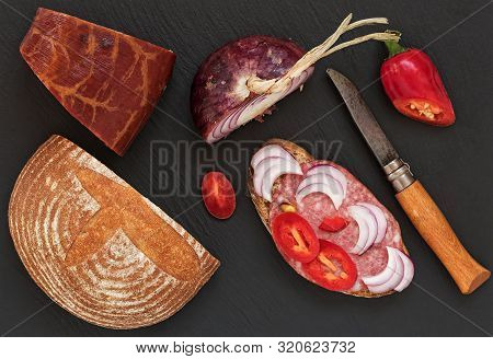 Salami, Sauce, With Peppers And Onions. View From Above. Black Stone Background.