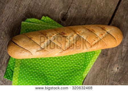 Sliced Long French Bread Over Wooden Table. Baguette. Restaurant