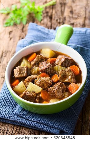 Fresh Homemade Beef Stew With Carrot And Potatoes Served In Green Bowl (selective Focus, Focus One T