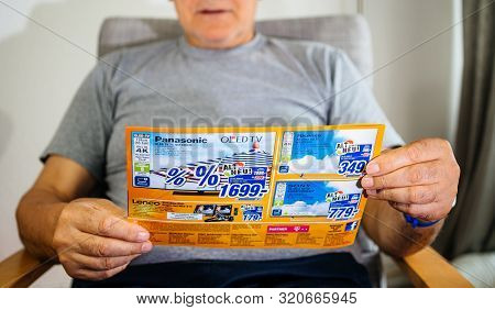 Paris, France - May 22, 2019: Male Hands Reading Flyer Advertising Featuring On The Cover Multiple H