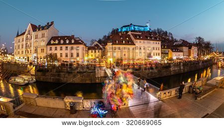 View Of Lively River Ljubljanica Bank In Old City Center Decorated With Christmas Lights At Dusk. Ol