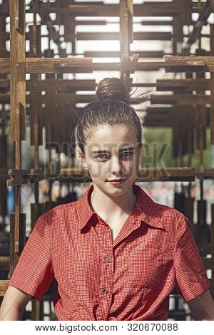 Outdoor Portrait Of A Young Woman With Topknot