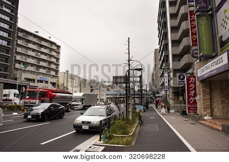 Landscape And Cityscape With Traffic And Japanese People Walking Beside Road Of Kannana Dori Street 