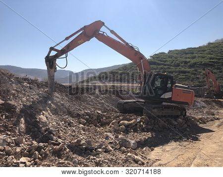 Hydrohammer Is Crushing Rocks During Road Construction Works On The Rocky Soils