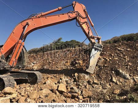 Hydrohammer Is Crushing Rocks During Road Construction Works On The Rocky Soils.