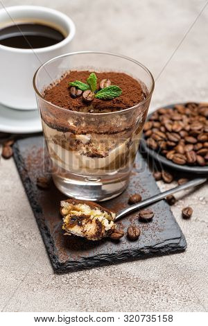 Portion Of Classic Tiramisu Dessert In A Glass Cup On Stone Serving Board And Fres Espresso Coffee O