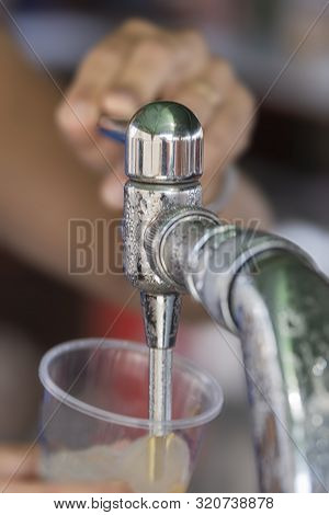 Vertical Image Of A Chrome Key Serving Beer In A Plastic Cup.