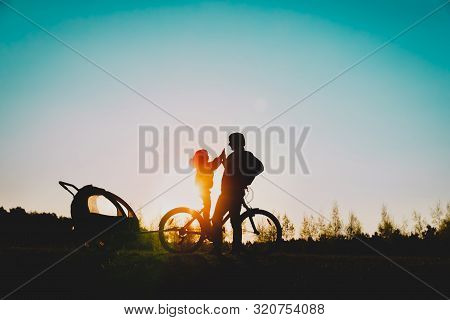 Happy Father And Little Daughter Riding Bike At Sunset
