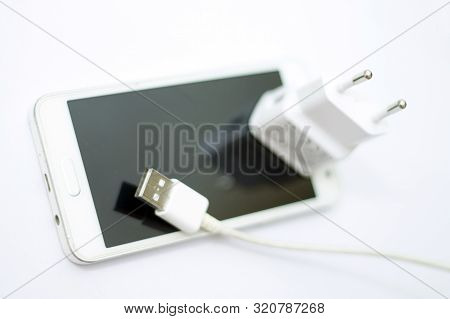 Modern Smartphone And Phone Charge With Power Cord Isolated On The White Bckground