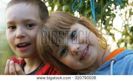Young Funny Boy And Girl Laugh Eating Ripe Rapberries