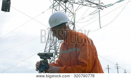Aged Survey Specialist Adjusts Dumpy Level On Tripod