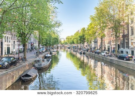 Amsterdam, Netherlands - June 6, 2019: View Of Canal From Sint Jansbrug Bridge.