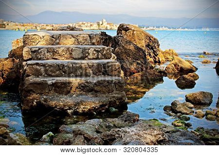 Old Tower Stone Stairs Isolated In Blue Sea Water Background With Rocks And Mountain