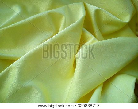 Crumpled Velvet Fabric Of Yellow Color With A Golden Sheen And The Play Of Light And Shadow