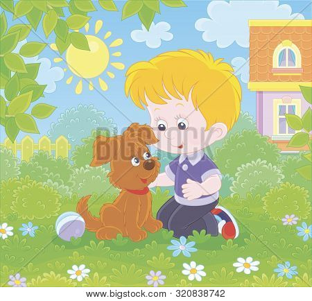 Little Boy Playing With A Small Brown Pup Among Flowers On Green Grass Of A Lawn In Front Of His Hou
